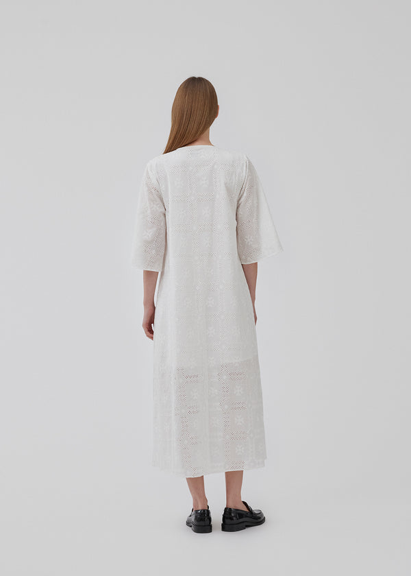 Broderie anglaise cotton dress in white with a casual fit and wide sleeves cutting at the elbow, and a opening in front with a tieband. HollynMD dress is lined. The model is 175 cm and wears a size S/36.