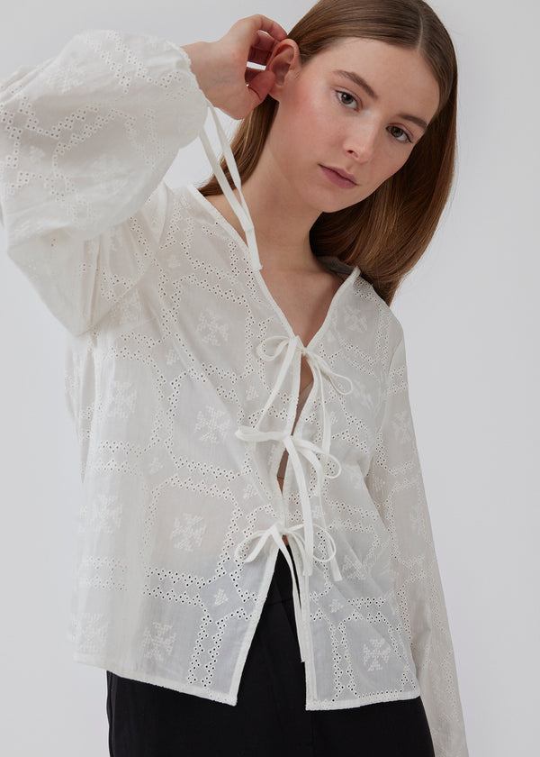 Broderie anglaise cotton shirt in white with three tiebands in front. HollynMD shirt has a normal fit and long wide. sleeves with a tieband at the end. The model is 176 cm and is wearing size S/36.