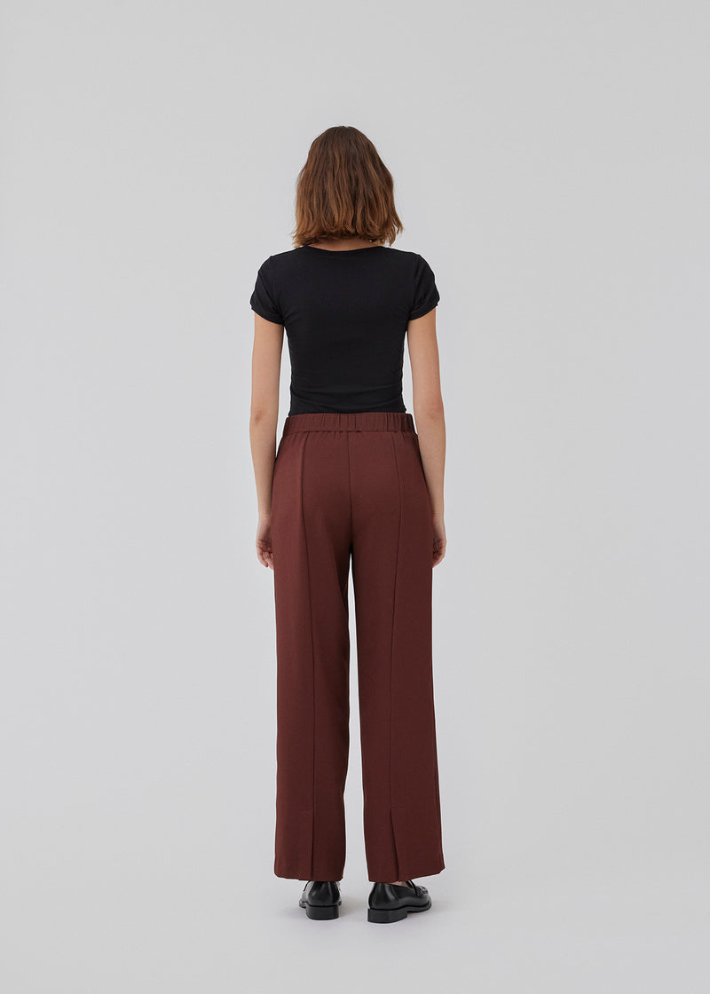 Pants with straight legs, high waist with button and fly and elastic in the back. HomerMD pants has cutlines in the back with a slit at the bottom. The model is 175 cm and wears a size S/36.