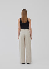 Pants in beige designed with a casual look and fit in a cotton and linen blend. HonorMD pants has loose legs and a medium waist with a wide elastic band. The model is 175 cm and wears a size S/36.