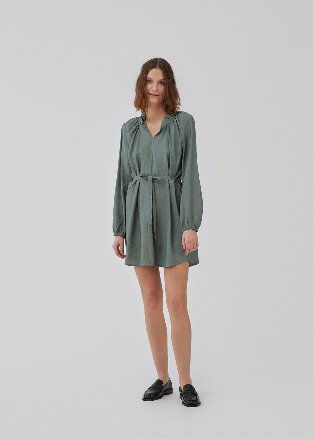 Short dress with long sleeves and a loose silhouette. HudgesMD dress has a v-shaped neckline with ruffles and a tiebelt at the waist. The model is 175 cm and wears a size S/36.