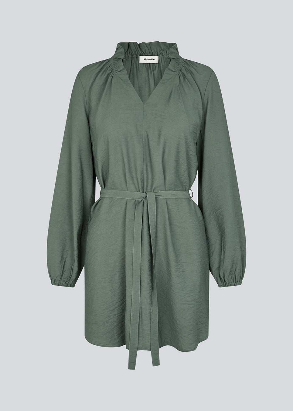 Short dress with long sleeves and a loose silhouette. HudgesMD dress has a v-shaped neckline with ruffles and a tiebelt at the waist. The model is 175 cm and wears a size S/36.