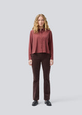 Red shirt in a light EcoVero viscose with a loose fit. HudgesMD shirt has a collar, button closure in front, and long sleeves with cuff. The model is 175 cm and wears a size S/36.