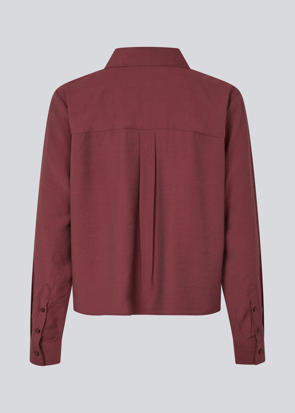 Red shirt in a light EcoVero viscose with a loose fit. HudgesMD shirt has a collar, button closure in front, and long sleeves with cuff. The model is 175 cm and wears a size S/36.