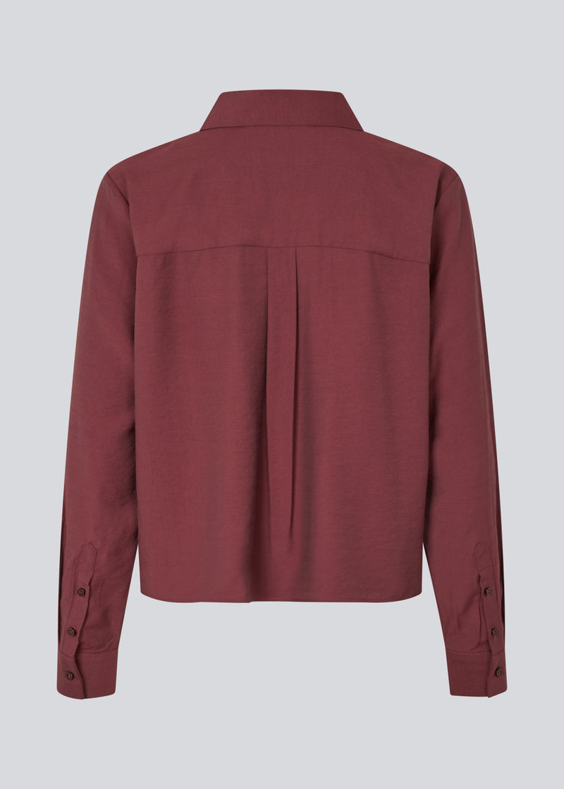 Red shirt in a light EcoVero viscose with a loose fit. HudgesMD shirt has a collar, button closure in front, and long sleeves with cuff. The model is 175 cm and wears a size S/36.