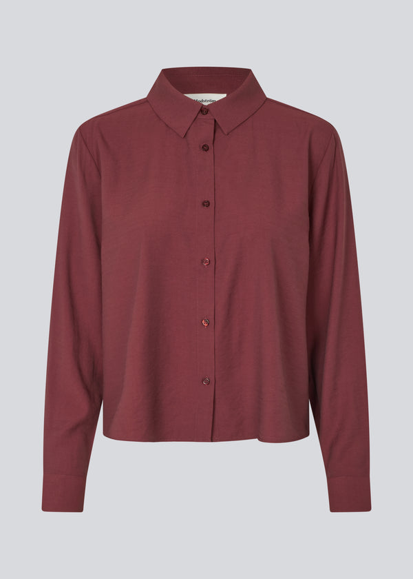 Red shirt in a light EcoVero viscose with a loose fit. HudgesMD shirt has a collar, button closure in front, and long sleeves with cuff. The model is 175 cm and wears a size S/36.