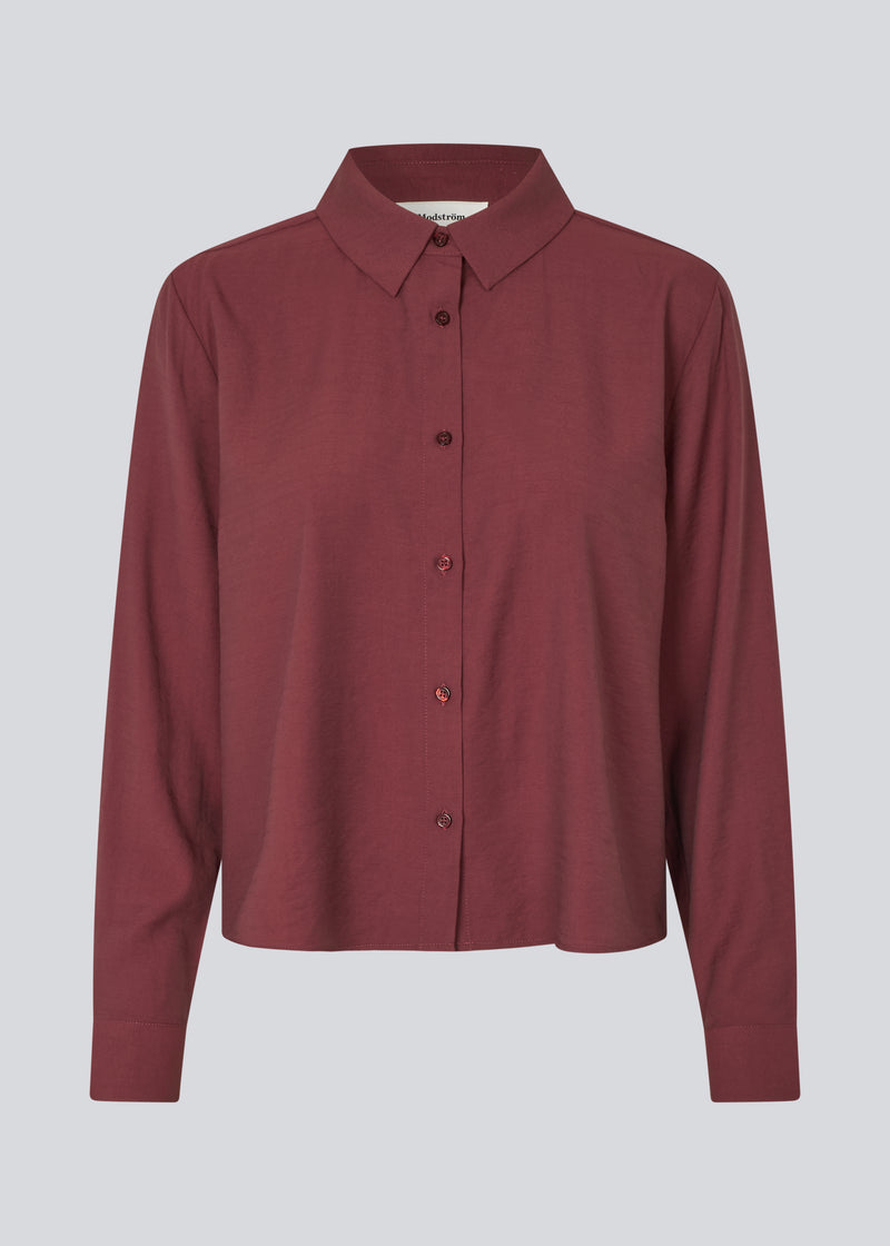 Red shirt in a light EcoVero viscose with a loose fit. HudgesMD shirt has a collar, button closure in front, and long sleeves with cuff. The model is 175 cm and wears a size S/36.