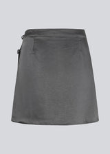 Wrap mini skirt in satin. HudsonMD skirt cuts at mid-thigh and is closed by a hidden contra-button and two tiebands at the waist. The model is 175 cm and wears a size S/36.