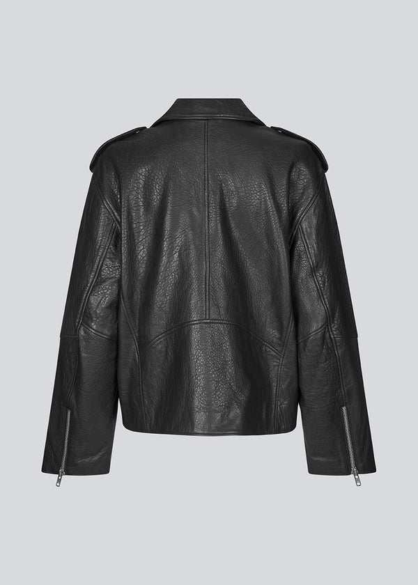 Jacket made from lamb leather in black with a slanted zipper in front, a lapel with push buttons, and long sleeves with a zipper at the hem. HullaMD solid jacket has slanted front pockets with a zipper in front. Lined. The model is 175 cm and wears a size S/36.