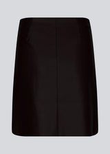 Short, asymmetrical wrap skirt in black in faux leather. HuxleyMD skirt has a hidden zipper closure at one side.