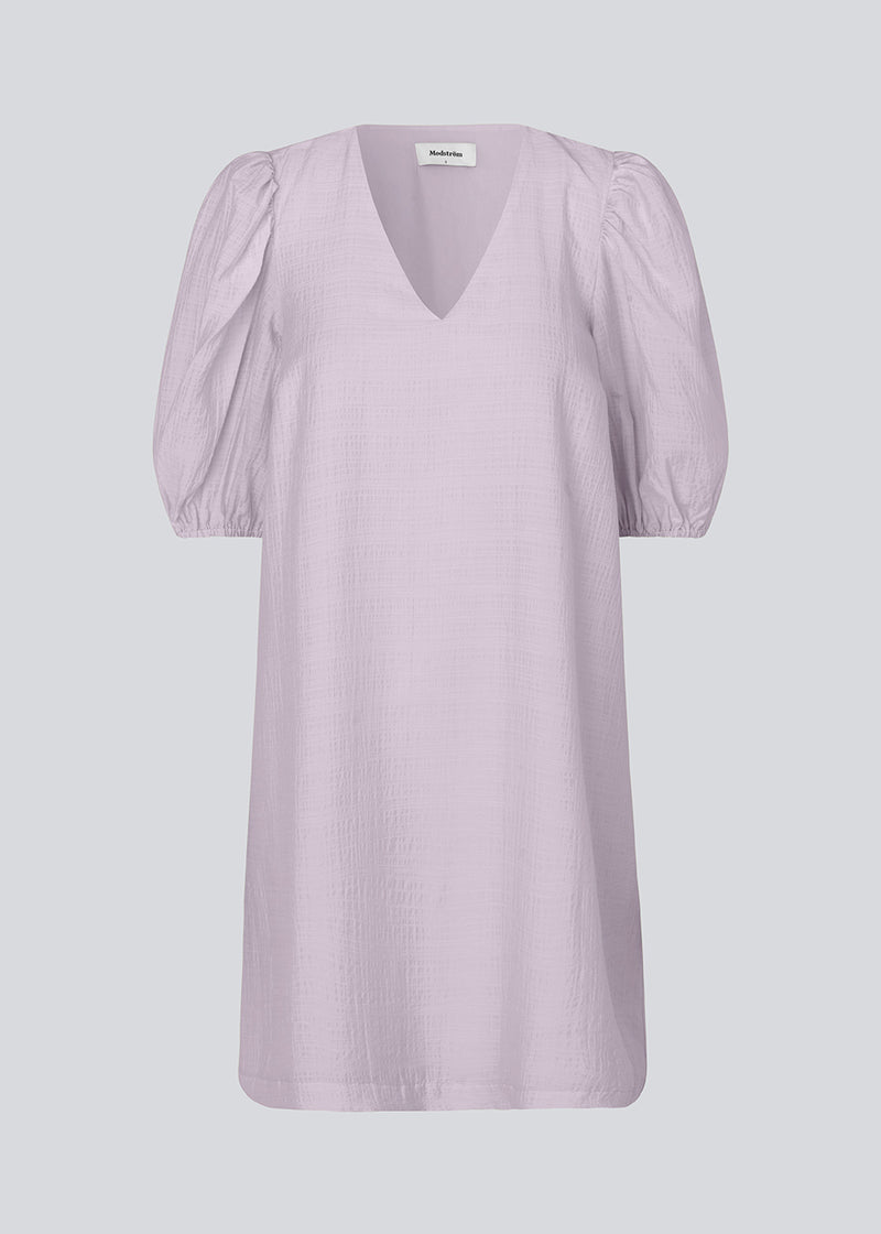 Midi dress in light purple in a loose fit with a V-neckline. IbiMD flare dress has puff sleeves with elastic at the end.