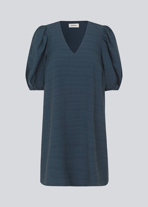 Midi dress in dark blue in a loose fit with a V-neckline. IbiMD flare dress has puff sleeves with an elastic at the end.