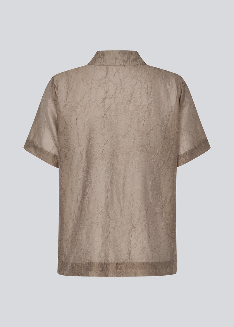 Loose shirt in light brown in a slightly transparent and structured material. IdrisMD shirt has short sleeves and a slit in the sides.