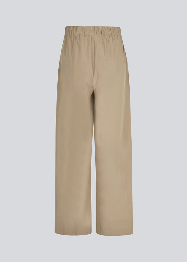 IlenaMD relaxed fit pants in light Brown cotton blend  Discover comfort and style with our IlenaMD Relaxed Fit Pants crafted in a breathable cotton blend. These pants feature an elastic waistband and convenient side pockets for added functionality, all in a stylish light brown color named "Dune."