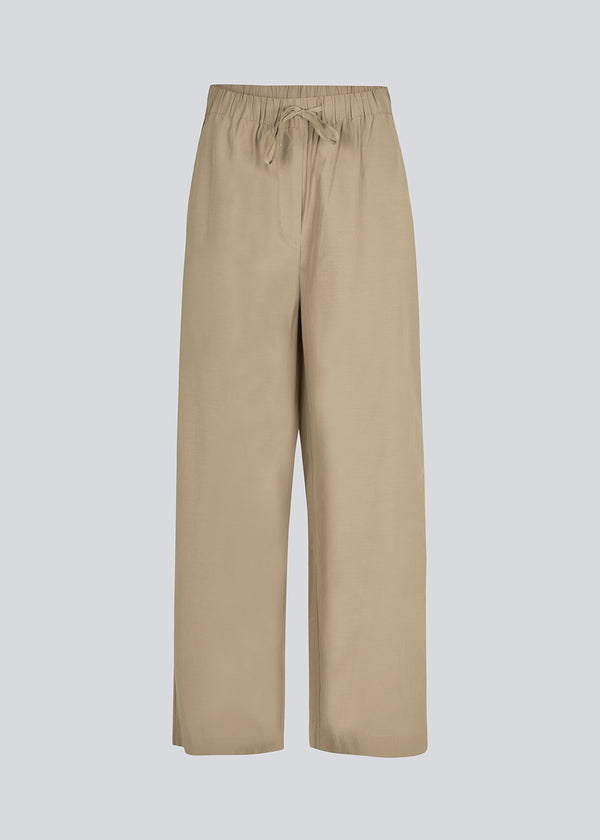 IlenaMD relaxed fit pants in light Brown cotton blend  Discover comfort and style with our IlenaMD Relaxed Fit Pants crafted in a breathable cotton blend. These pants feature an elastic waistband and convenient side pockets for added functionality, all in a stylish light brown color named "Dune."