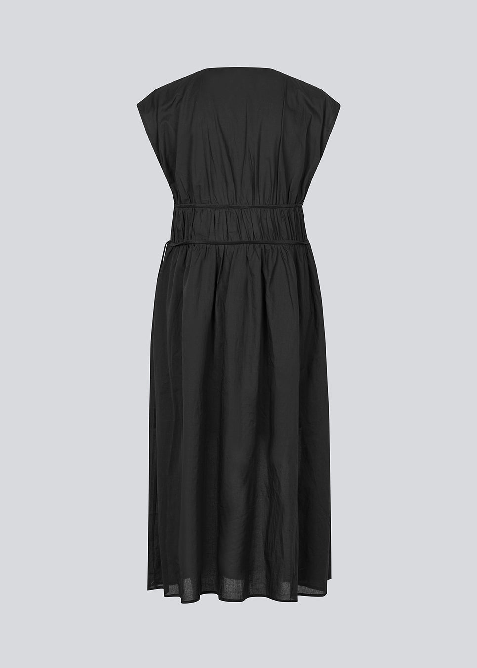 Sleeveless black maxi dress with a loose fit. IndiaMD dress has a deep v-neckline and a tie band at the waist and under the chest. The model is 177 cm and wears a size S/36.