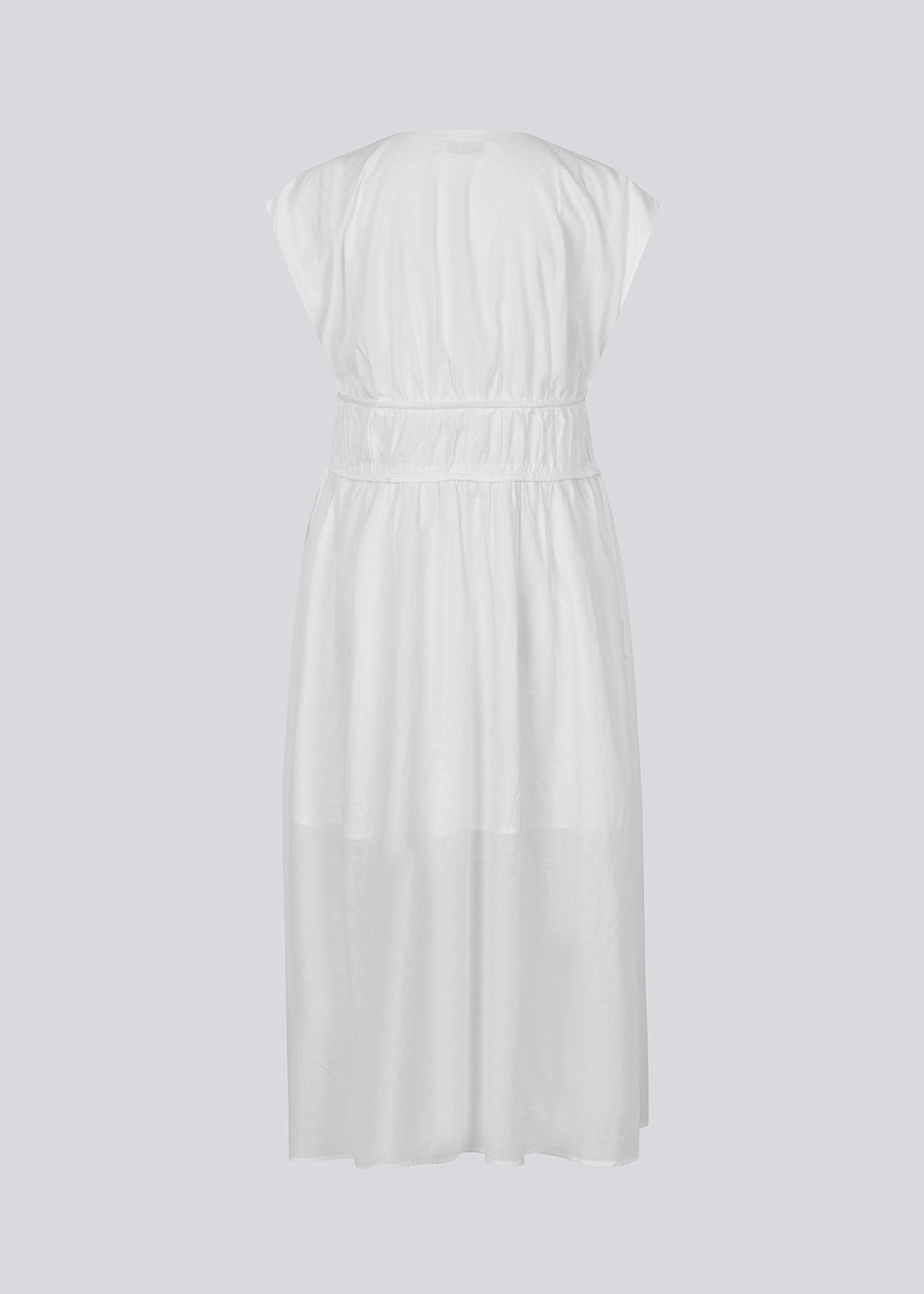 Sleeveless white maxi dress with a loose fit. IndiaMD dress has a deep v-neckline and a tie band at the waist and under the chest. The model is 177 cm and wears a size S/36.