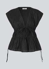 Sleeveless black top in a loose fit. IndiaMD top has a deep v-neckline and tie bands at the waist and under the chest.