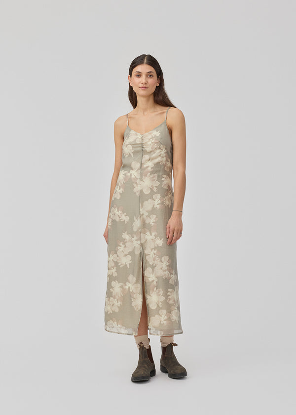 Long dress with thin straps and an elastic gathering at the chest. InduMD print dress has a slit in the front and an invisible zipper at the back. The model is 177 cm and wears a size S/36.