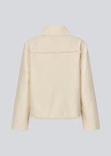 Jacket with loose sleeves, shirt collar, and a button closure in front. IngridMD jacket has raw edges in the front, back, and bottom.