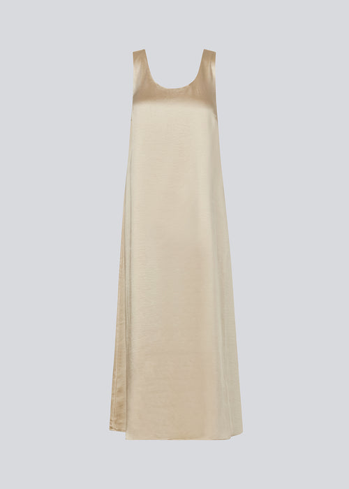 Long dress in beige in satin with an A-line silhouette. IolaMD dress has a deep back neckline and wide straps. The model is 177 cm and wears a size S/36.