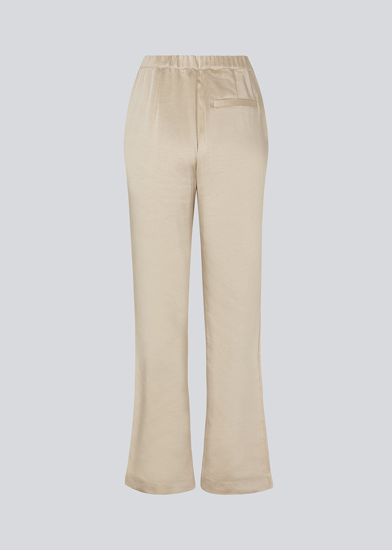 Flared pants in satin with an elastic in the back. IolaMD pants have a high waist, side pockets and a paspoli back pocket.