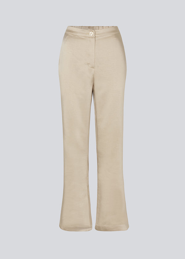 Flared pants in satin with an elastic in the back. IolaMD pants have a high waist, side pockets and a paspoli back pocket.