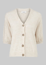Trendy cardigan in beige with short puffy sleeves and button closure at the front. Irene cardigan comes in a soft material perfect for the early spring days. The model is 174 cm and wears a size S/36