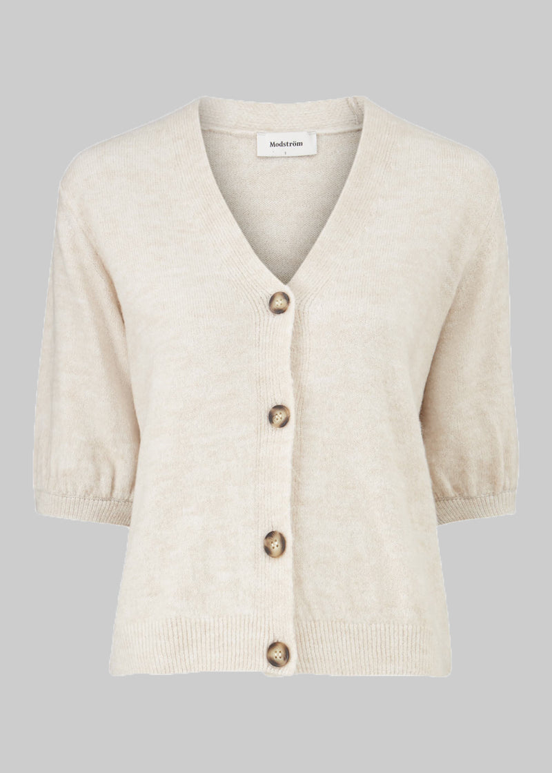 Trendy cardigan in beige with short puffy sleeves and button closure at the front. Irene cardigan comes in a soft material perfect for the early spring days. The model is 174 cm and wears a size S/36