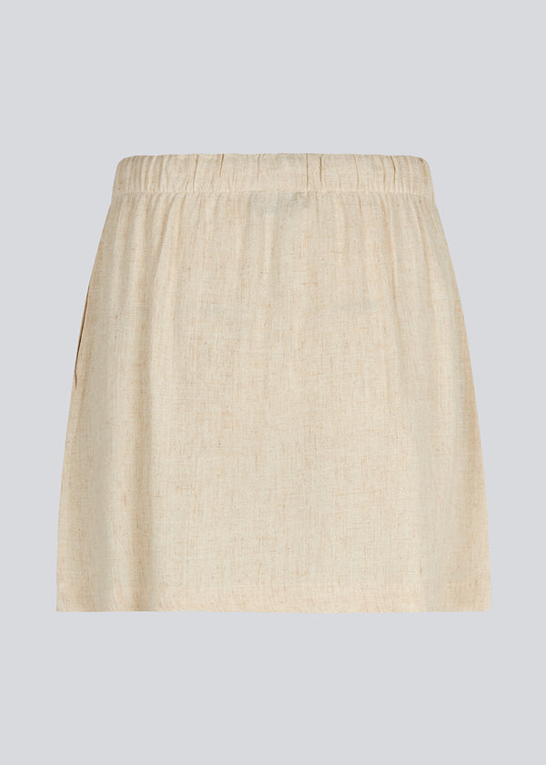 Short skirt in a linen blend and tiebands. IrfanMD skirt has a medium high waist with an elastic band and side pockets.
