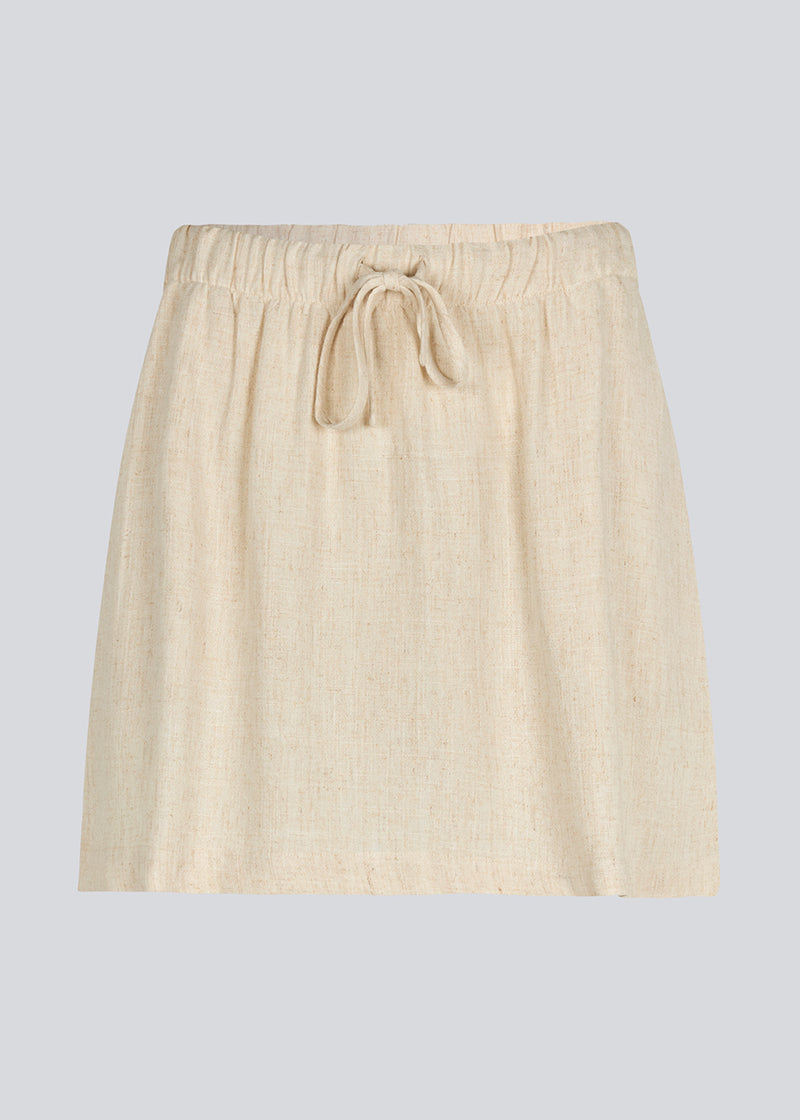 Short skirt in a linen blend and tiebands. IrfanMD skirt has a medium high waist with an elastic band and side pockets.