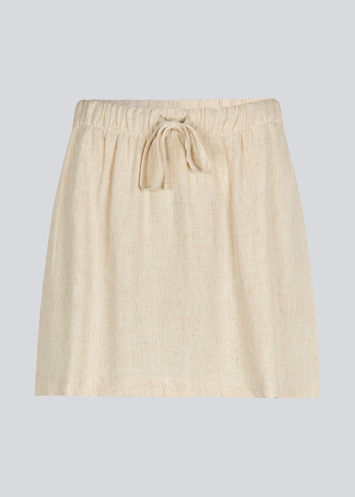 Short skirt in a linen blend and tiebands. IrfanMD skirt has a medium high waist with an elastic band and side pockets.