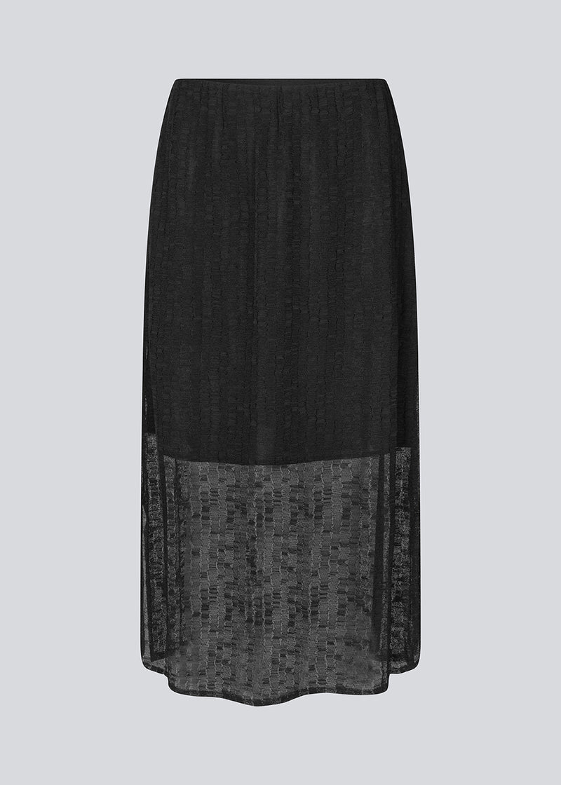 Maxi skirt in a slightly transparent material. IrmaMD skirt has an elastic waistband, slit in the side and lining.