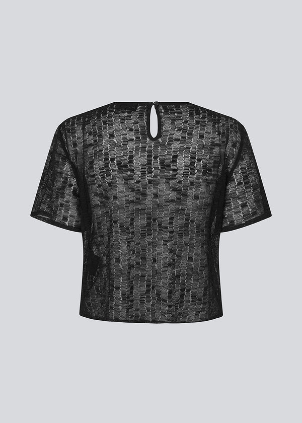 Loose t-shirt in a slightly transparent material. IrmaMD top has a neck opening which is closed with a button.