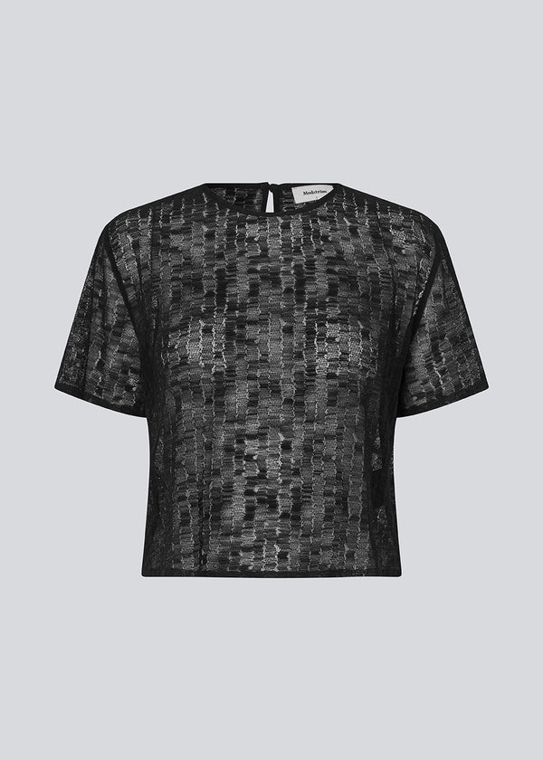 Loose t-shirt in a slightly transparent material. IrmaMD top has a neck opening which is closed with a button.
