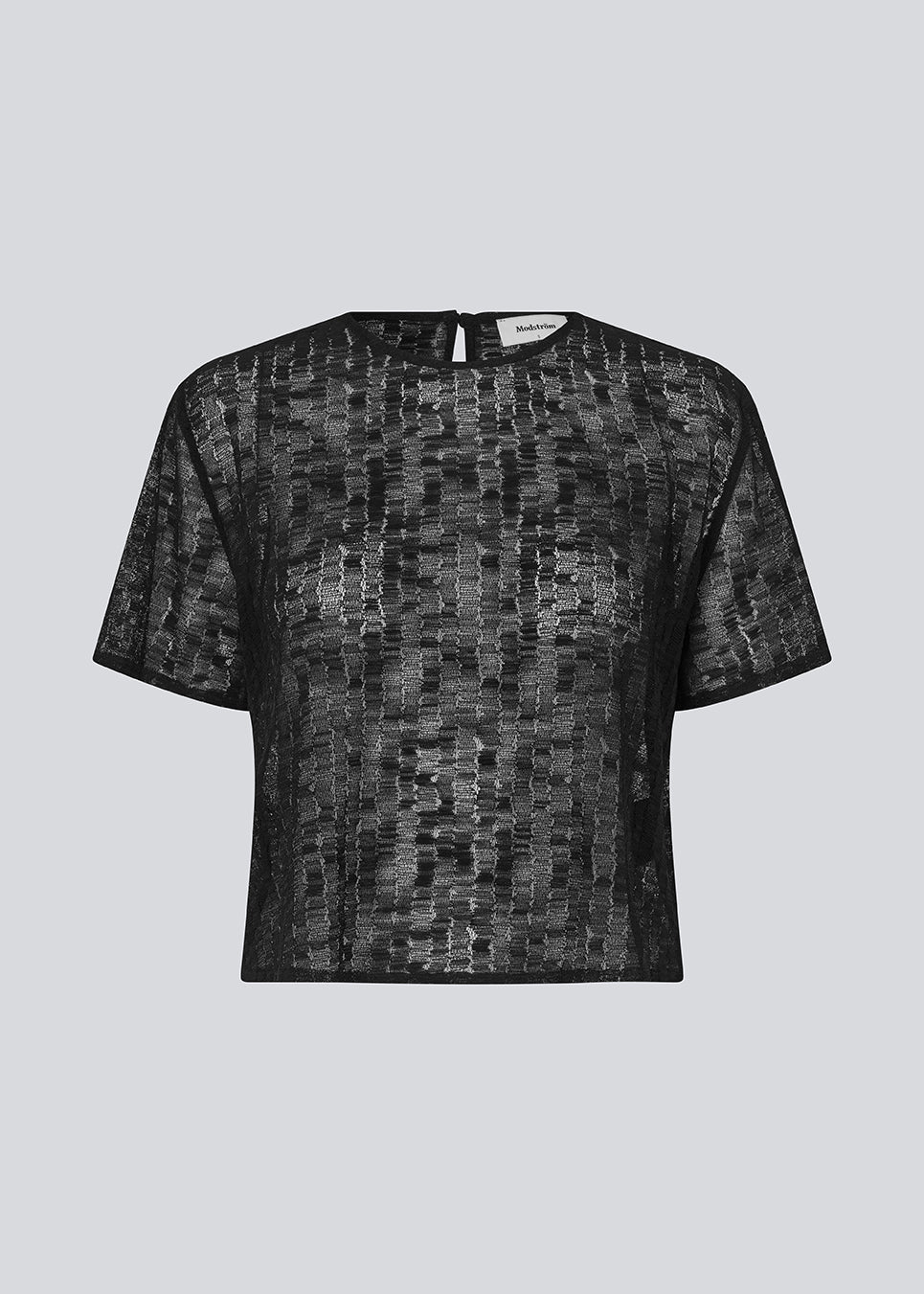 Loose t-shirt in a slightly transparent material. IrmaMD top has a neck opening which is closed with a button.