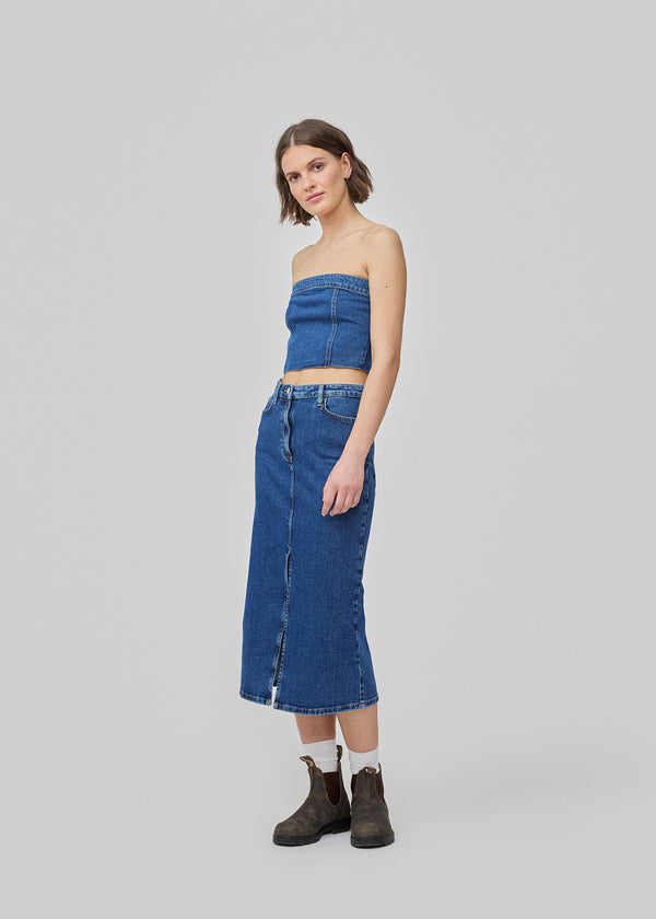 Midi skirt in denim. IvannaMD skirt has a medium-high waist, a slit in the front, and front and back pockets. The model is 177 cm and wears a size S/36.