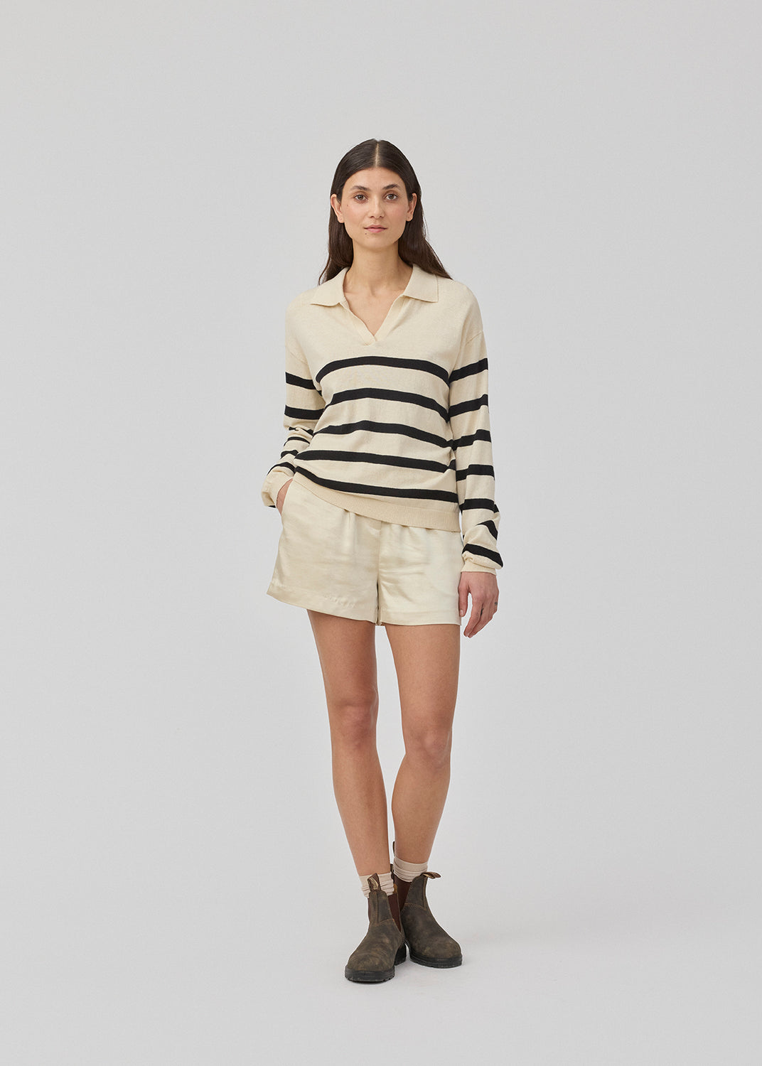 Soft knit/blouse with a v-neckline and a shirt collar. IvoryMD v-neck has ribbed edges at the bottom and sleeves. The knit is beige with black stripes.&nbsp;