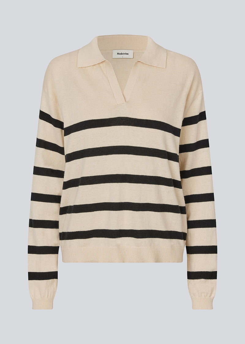 Soft knit/blouse with a v-neckline and a shirt collar. IvoryMD v-neck has ribbed edges at the bottom and sleeves. The knit is beige with black stripes.&nbsp;