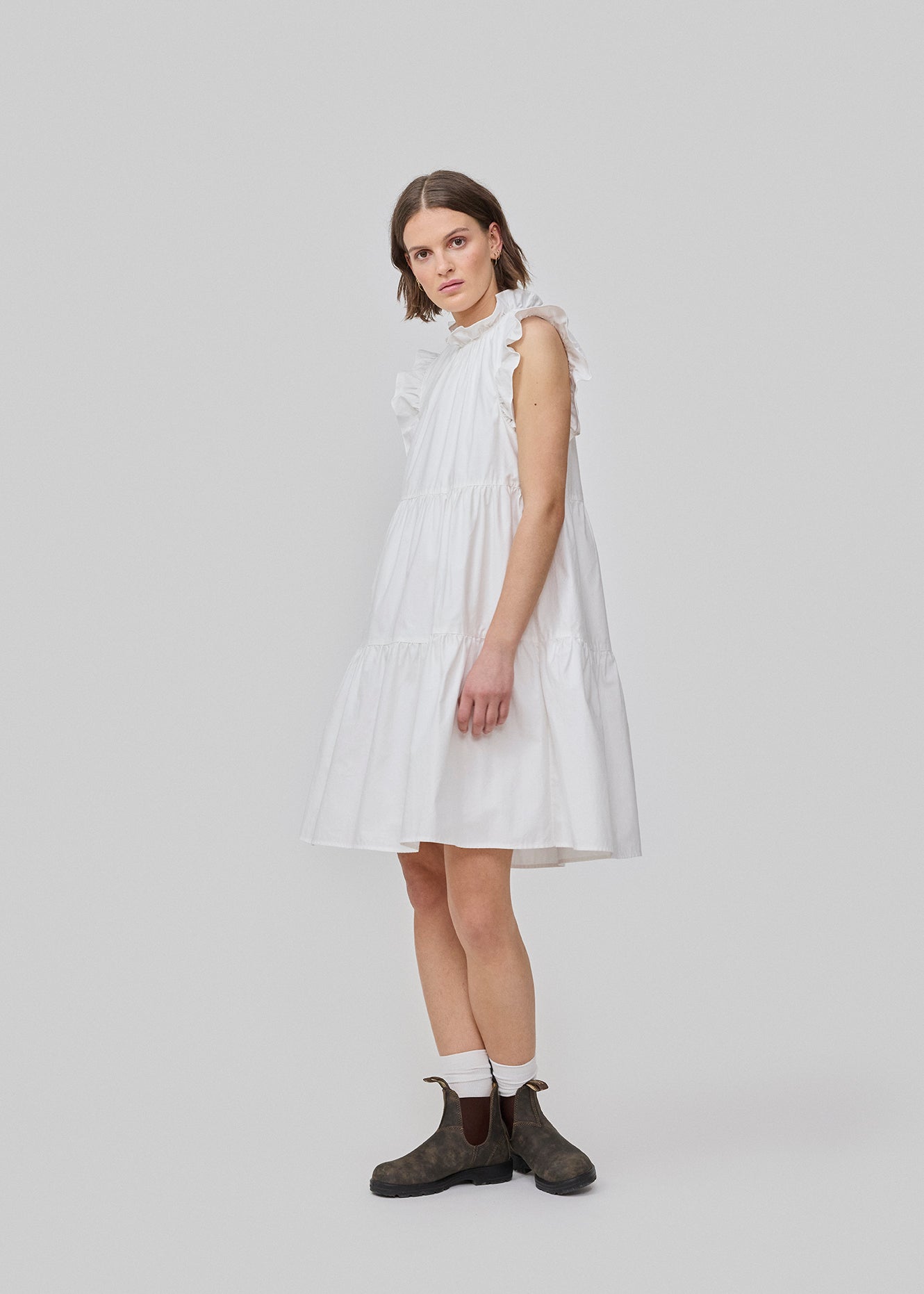 Sleeveless white dress in casual fit. The IZakMD dress has a ruffle detail at the sleeve and neck and is closed with a hidden zipper in the back. The model is 177 cm and wears a size S/36.