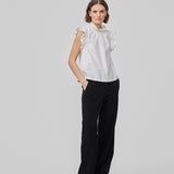 Loose white top with a ruffle detail at the sleeves and neck. IzakMD top is sleeveless and has a hidden zipper in the back. The model is 177 cm and wears a size S/36.