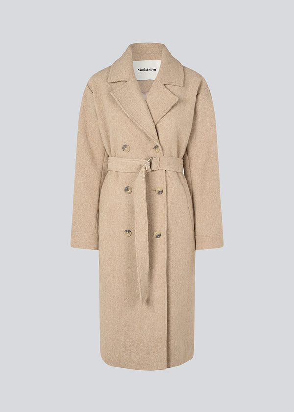 Long beige coat in twill with a tieband. JakariMD coat has wide revers, buttonclosure and a slit in the back.