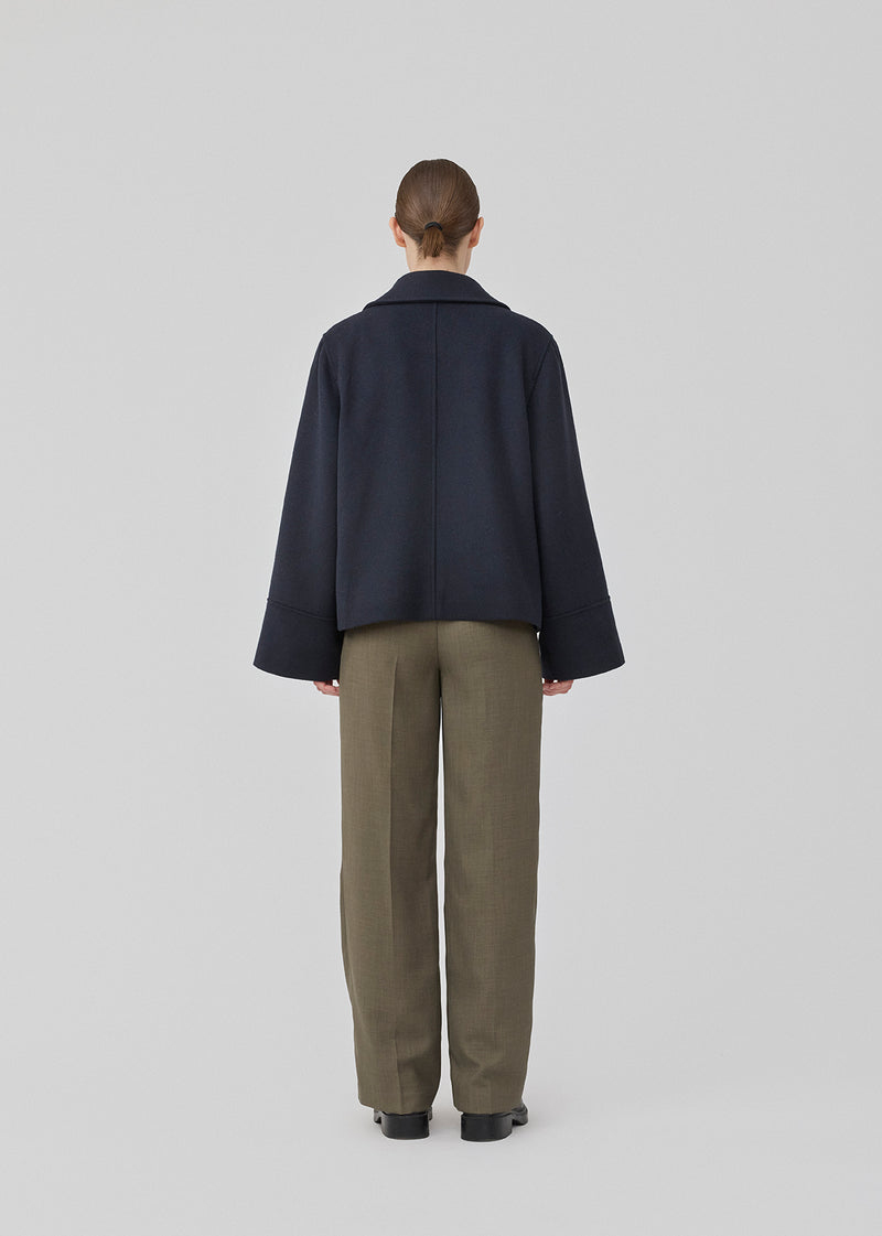 Jacket in a navy color with a loose fit and wide sleeves in a wool mix. JannaMD jacket has two pockets in front, collar and a zipper closure in the side.