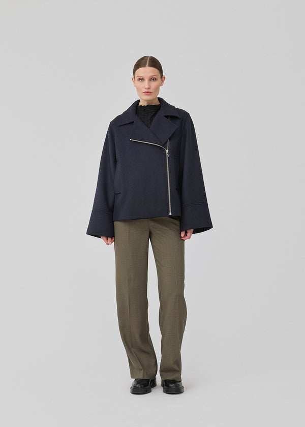 Jacket in a navy color with a loose fit and wide sleeves in a wool mix. JannaMD jacket has two pockets in front, collar and a zipper closure in the side.