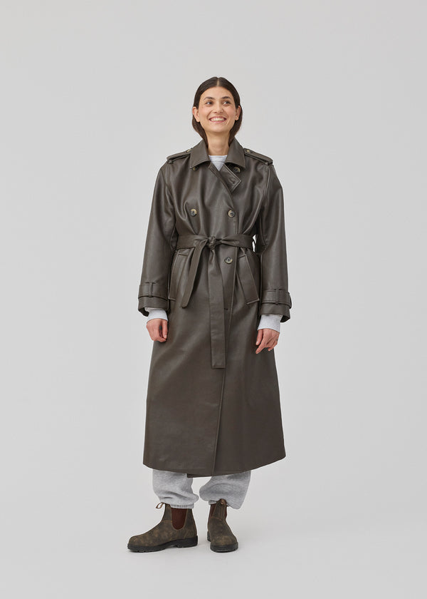 Double-breasted trench coat with tieband at the waist in a soft PU material. JoseeMD jacket has long wide sleeves, sidepockets and a slit in the back.