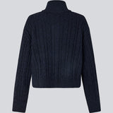 Josefine Vogt – high-neck cardigan. The Josefinemd knit cardigan features a cable-knit design with a high collar, buttoned cuffs, and front pockets. Timeless and perfect for chilly days, or as a layering piece over dresses and tops.