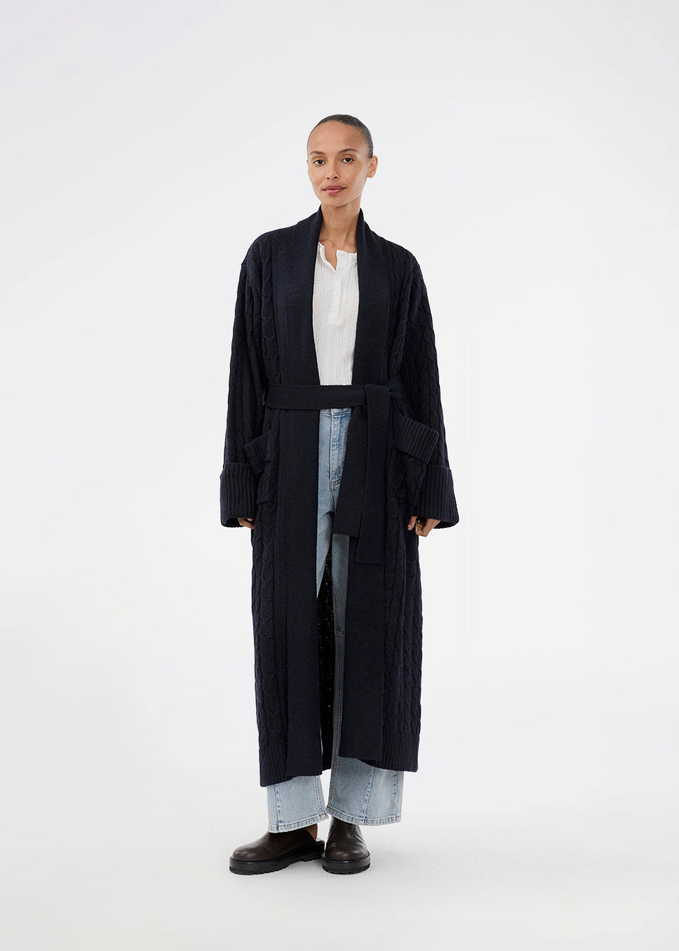 Blue cable-knit long cardigan. The Josefinemd robe is a long cardigan featuring pockets and a tie belt. Perfect for cozy mornings and chilly winter days.&nbsp;Josefine Vogt (165 cm) and the model (177 cm) are both wearing size Small.