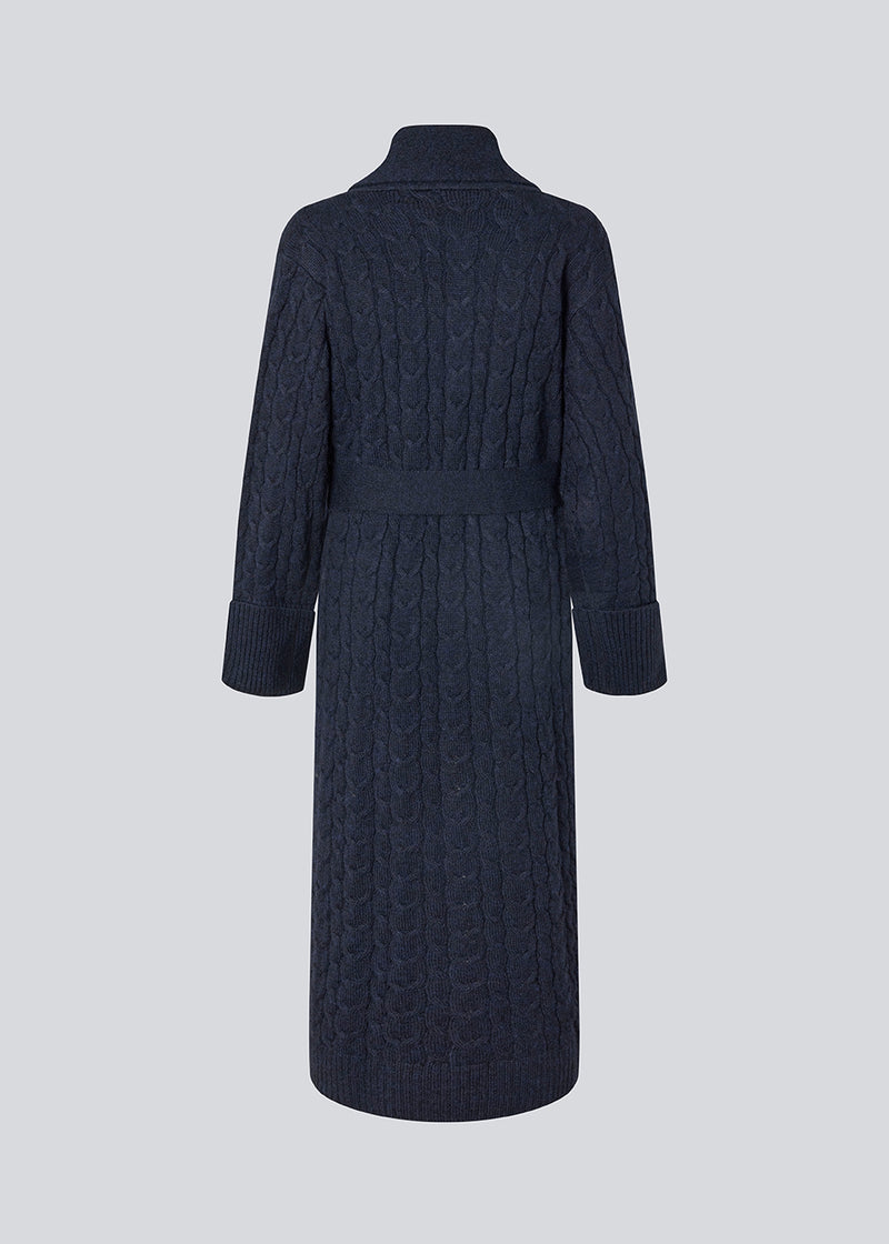 Blue cable-knit long cardigan. The Josefinemd robe is a long cardigan featuring pockets and a tie belt. Perfect for cozy mornings and chilly winter days.&nbsp;Josefine Vogt (165 cm) and the model (177 cm) are both wearing size Small.