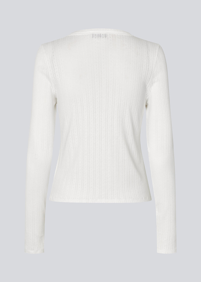 White fitted long-sleeve pointelle t-shirt. Josefinemd LS t-shirt is crafted in pointelle cotton with lace trim. The feminine cut and subtle openwork pattern give this classic style an elegant touch. Josefine Vogt (165 cm) and the model (177 cm) are both wearing size Small.