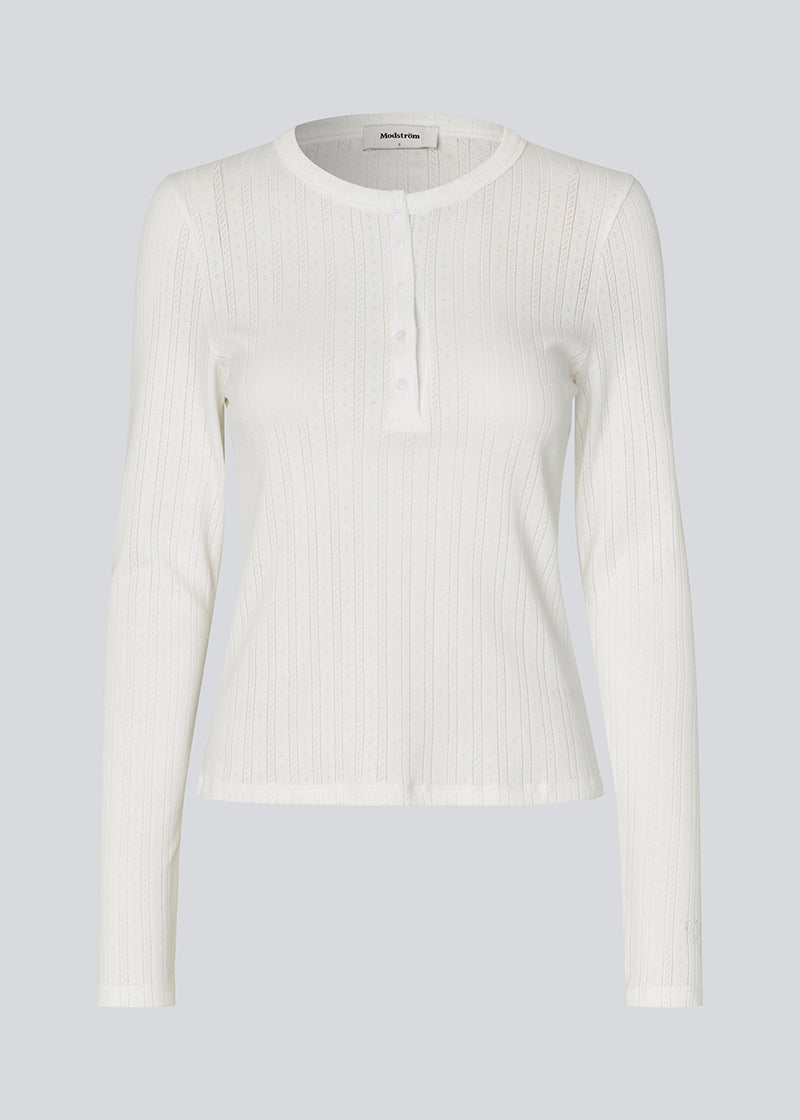 White fitted long-sleeve pointelle t-shirt. Josefinemd LS t-shirt is crafted in pointelle cotton with lace trim. The feminine cut and subtle openwork pattern give this classic style an elegant touch. Josefine Vogt (165 cm) and the model (177 cm) are both wearing size Small.